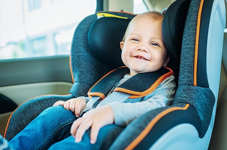 תינוק מחייך יושב במושב בטיחות ברכב